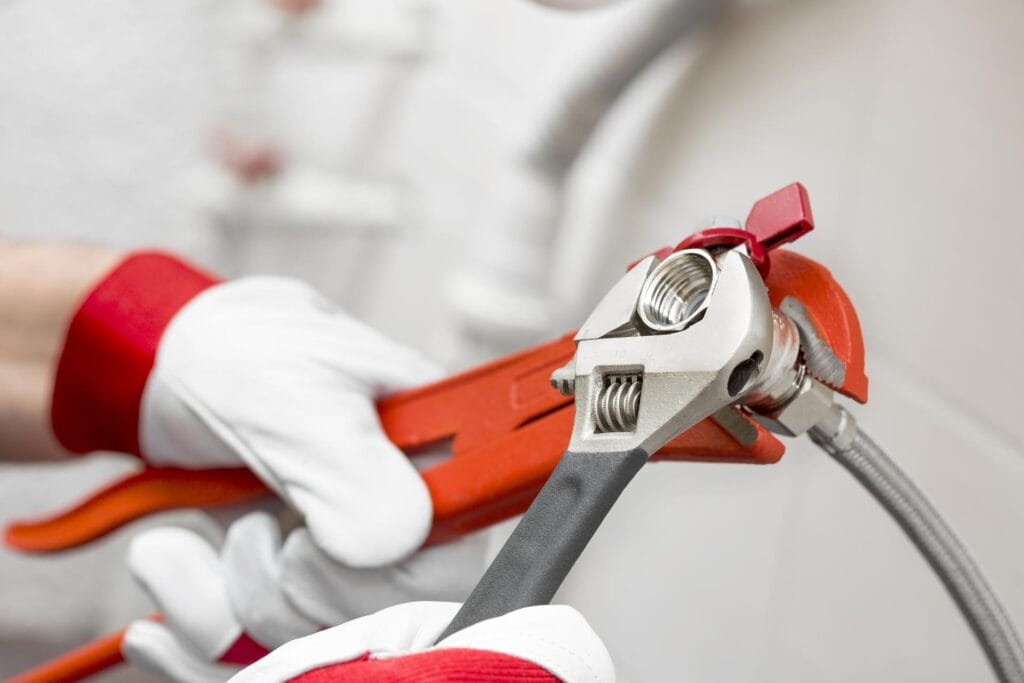 Plumber holding pipe wrenches for an emergency repair in Bradenton