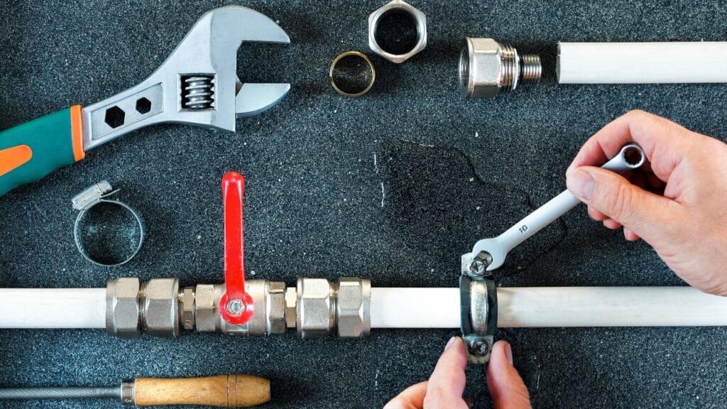 Plumber repairing a pipe valve with an adjustable wrench in Bradenton