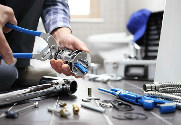 Technician repairing a plumbing fixture with professional tools in Bradenton