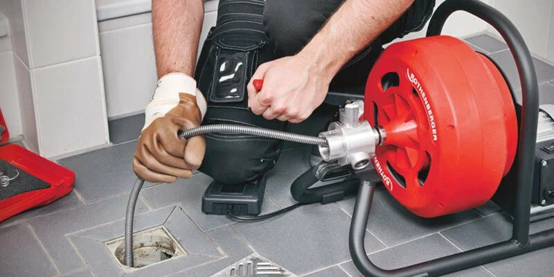 Plumber using a drain-cleaning machine in Bradenton