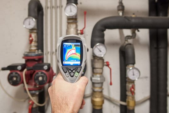 Plumber using a thermal imaging camera to inspect pipes in Bradenton