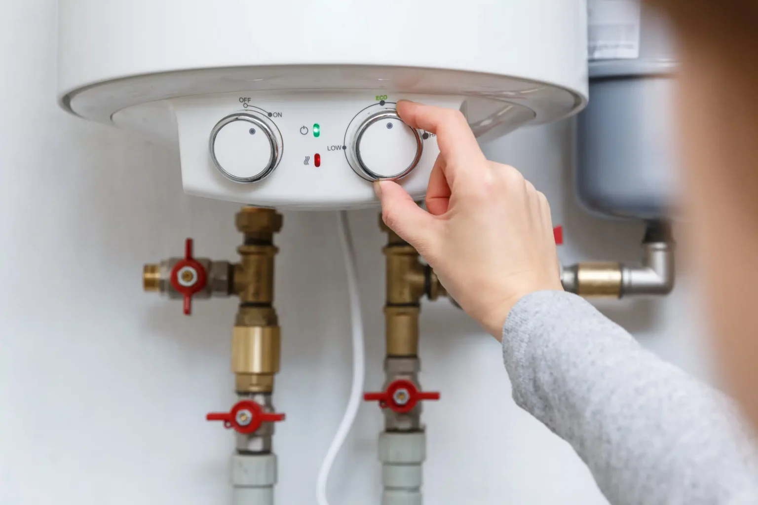 Homeowner adjusting the temperature controls on a water heater in Bradenton